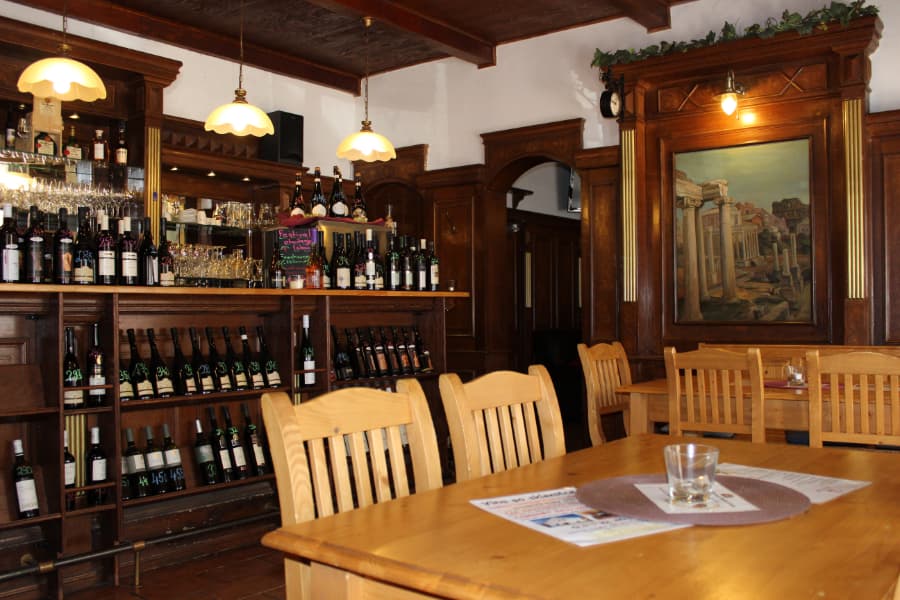 Interiér Pálavské vinárny — dubový bar, křídou psané ceny a olejomalba Fóra Romana